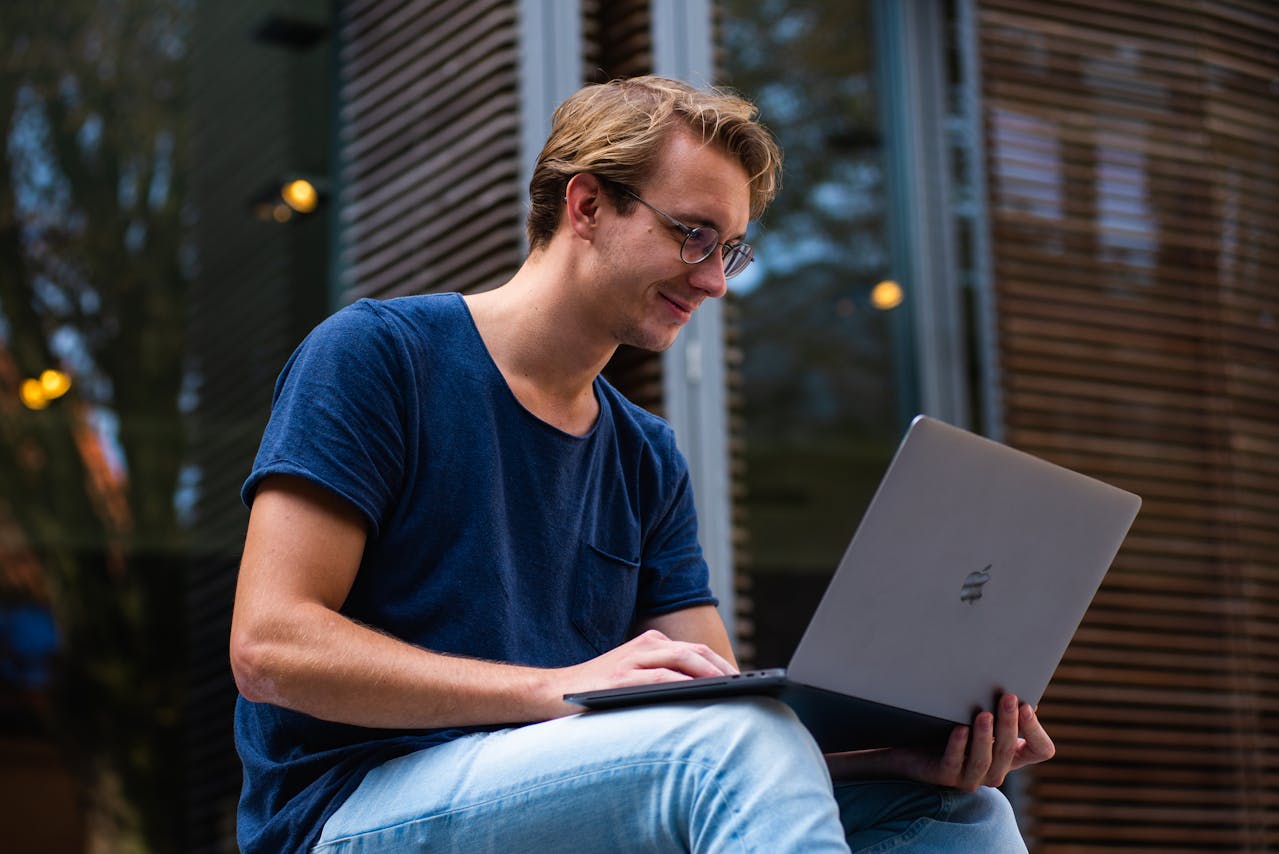 Man smiling while working on laptop